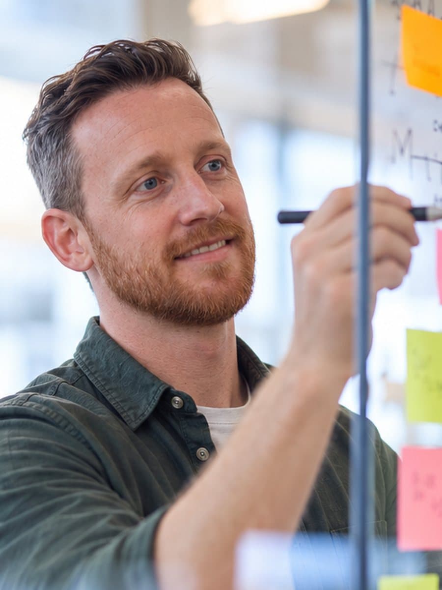Lucas schetst een klantreis op een whiteboard met post-its